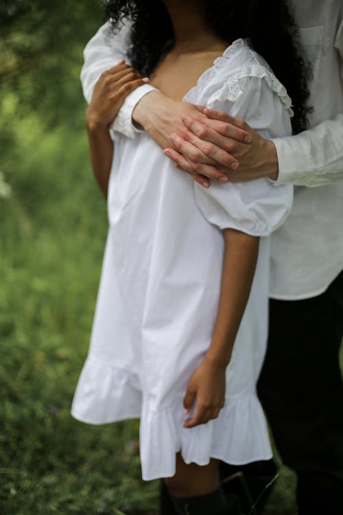 Free Man in White Dress Shirt Holding Woman in White Dress Stock Photo