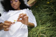 Girl in White Dress Lying on Green Grass Field