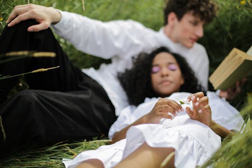 Man and Woman Lying on Grass Field