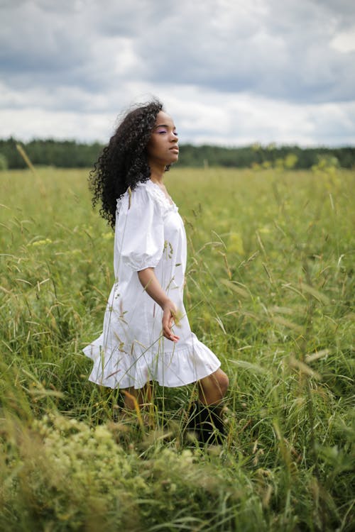 Girl in White Dress Standing on Green Grass Field