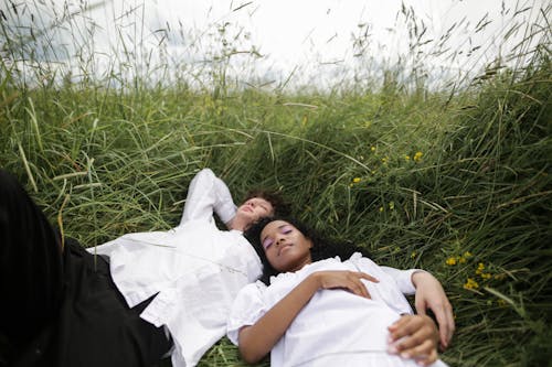 Free Woman in White Dress Lying on Green Grass Stock Photo