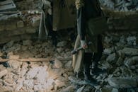 Man in Black Jacket Holding Black Metal Pipe