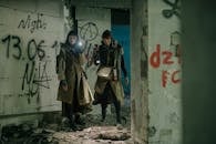 Man in Black Jacket Standing Beside Woman in Brown Coat