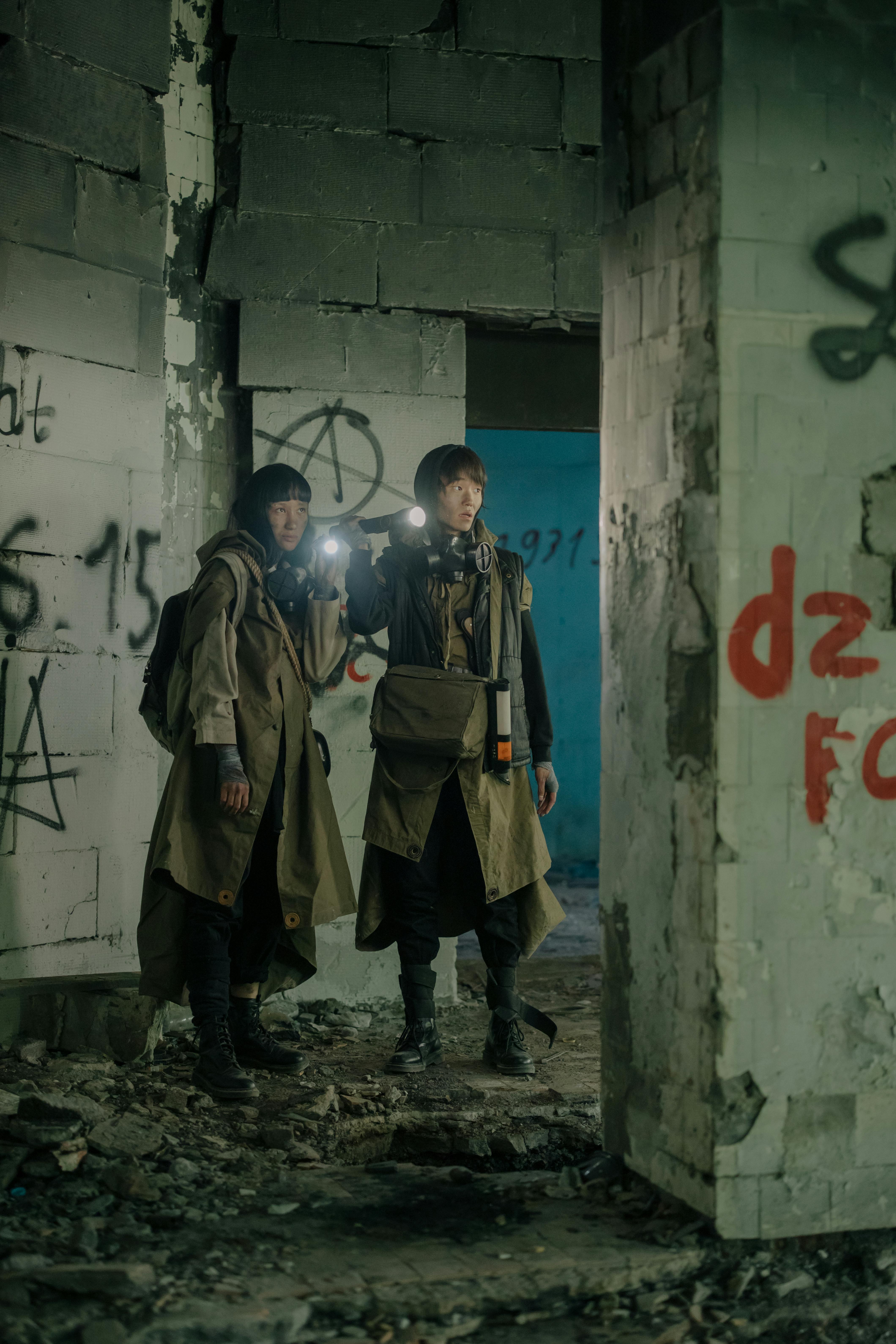 2 men in brown coat standing beside white wall