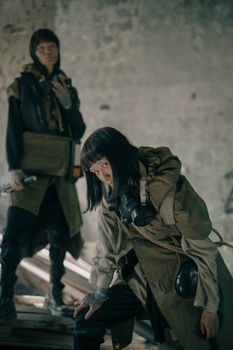 两个穿着反乌托邦风格服装的人正在探索一座废弃建筑