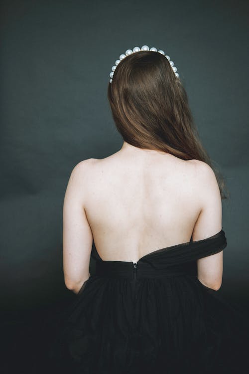 Faceless woman in dress with no back in studio