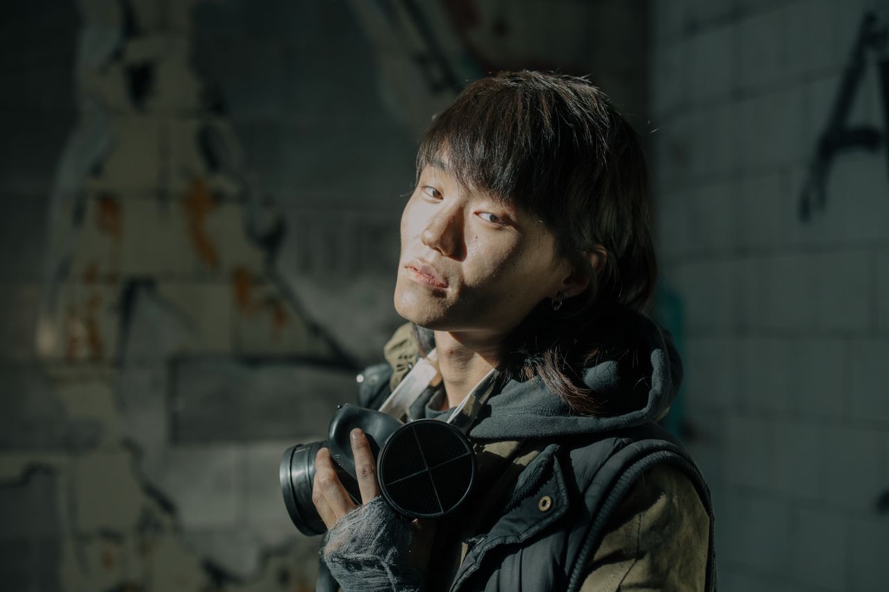 portrait of a young man with gas mask in a decayed urban setting