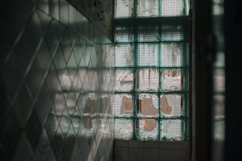 Man in White Shirt Standing Beside Window