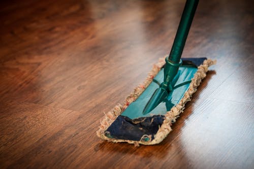 Closeup Of Janitor Sweeping Hardwood Floor Stock Photo - Download
