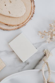 Flat lay of a natural soap bar and loofah on a marble countertop for eco-friendly hygiene.