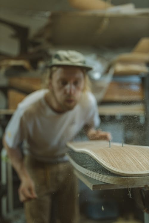 Photograph of a Man with a Cap Blowing Dust 