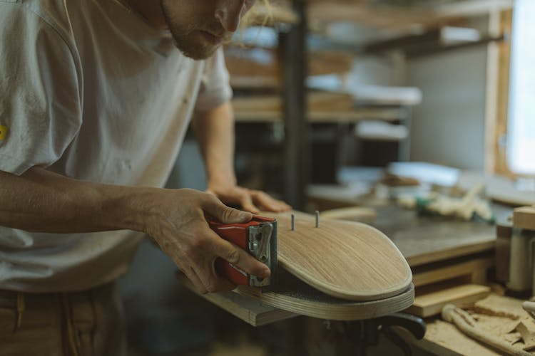 Photo Of A Man Sanding A Skateboard