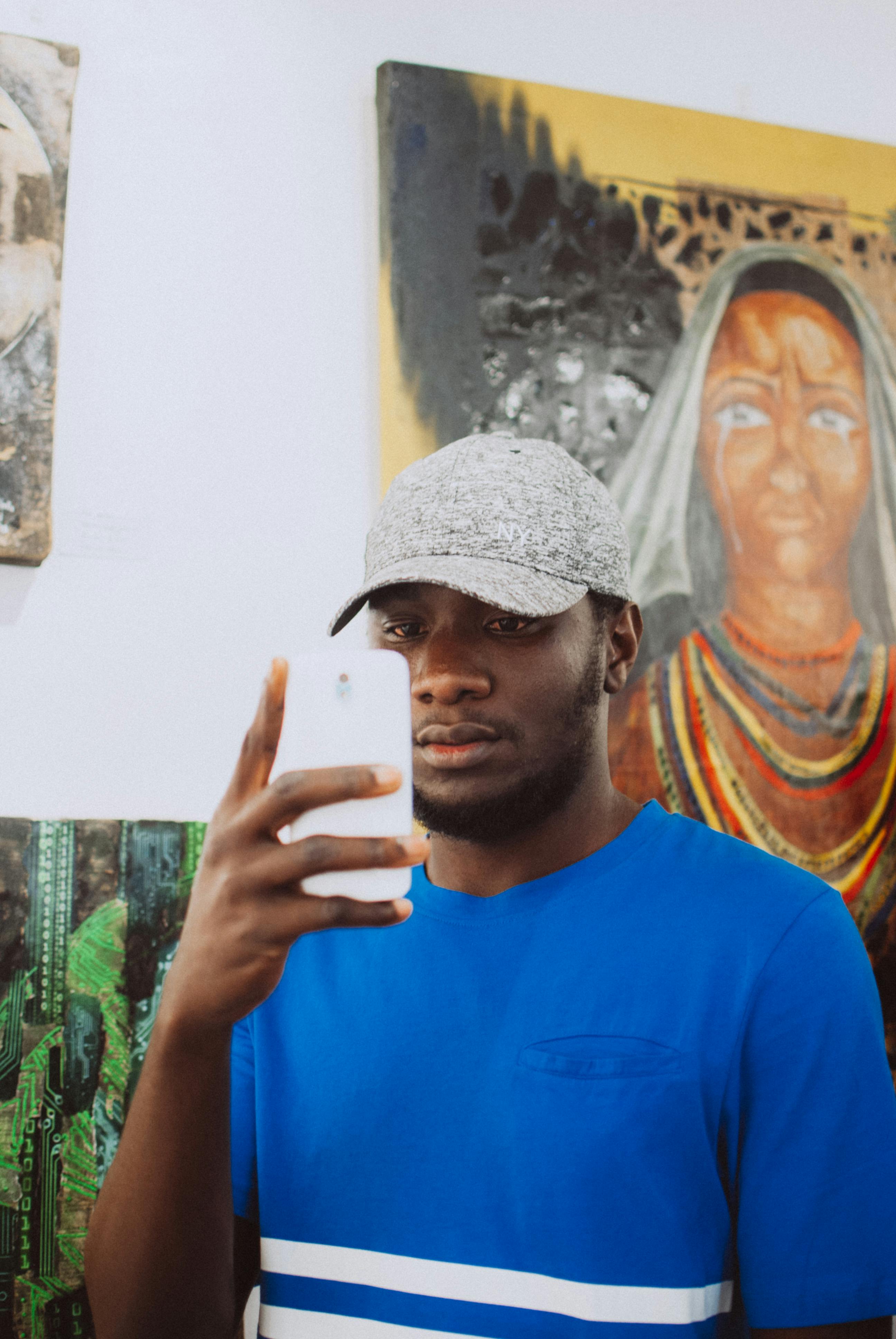 focused black man taking selfie in gallery