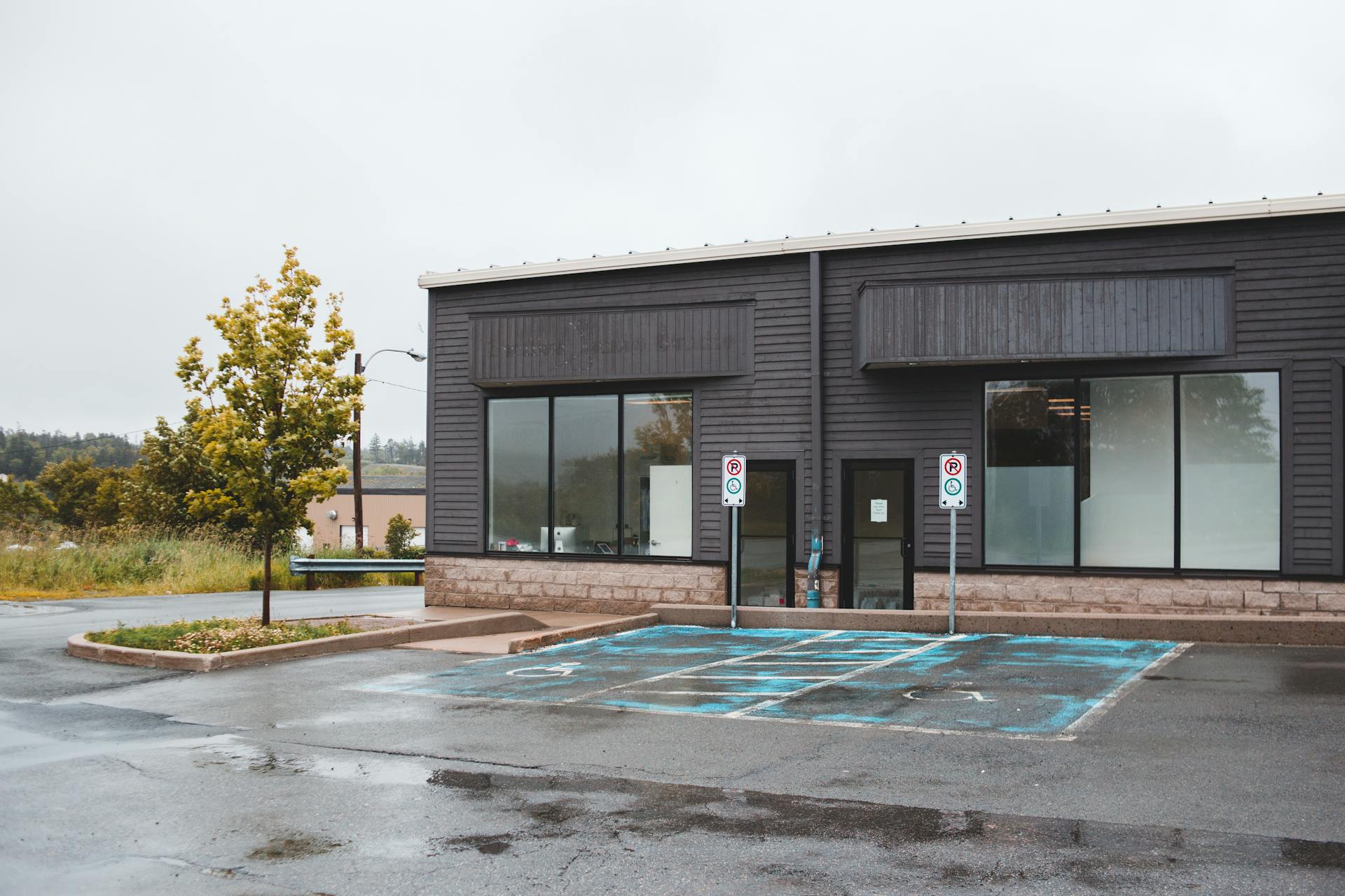 Modern office building with big windows and empty parking lot for people with disabilities