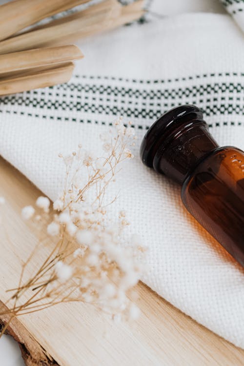 Photo of a Brown Bottle Near White Flowers