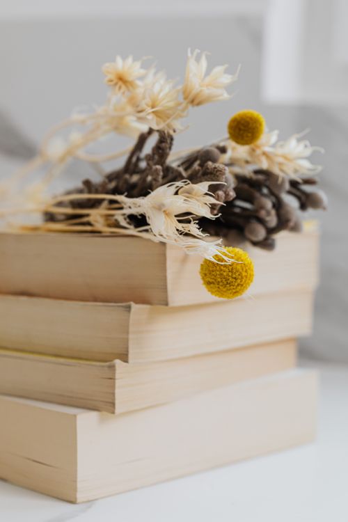 Free Artistic stack of books with dried flowers creating a cozy, vintage aesthetic. Stock Photo
