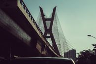 From below contemporary concrete bridge with geometric futuristic details located in urban city