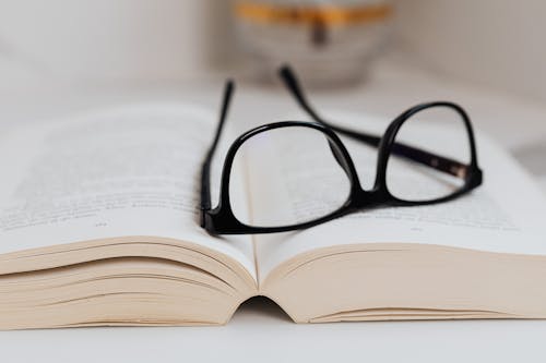 Free Black Framed Eyeglasses on on the Book Stock Photo