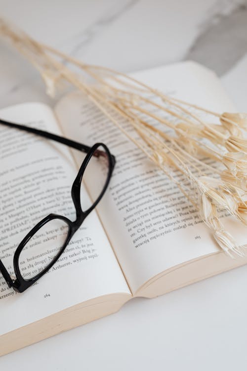 Photo of Black Eyeglasses on Top of a Book