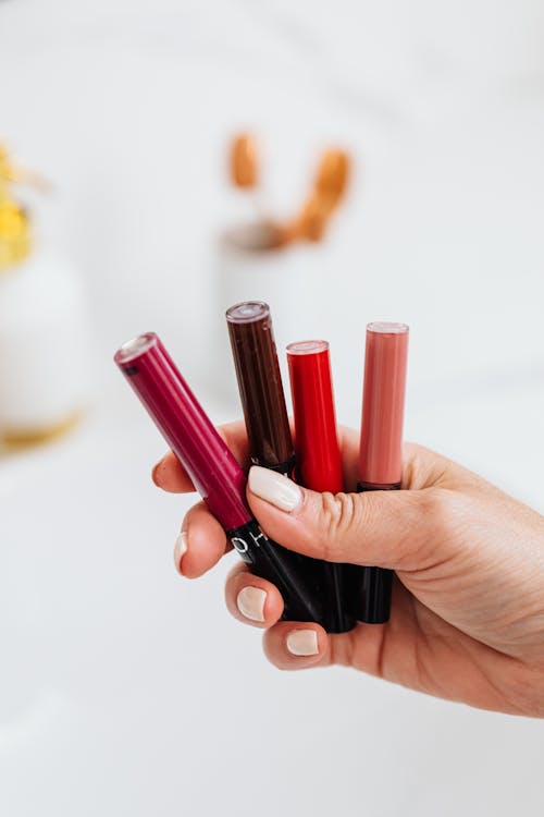 Photo of a Person's Hand Holding Lipsticks