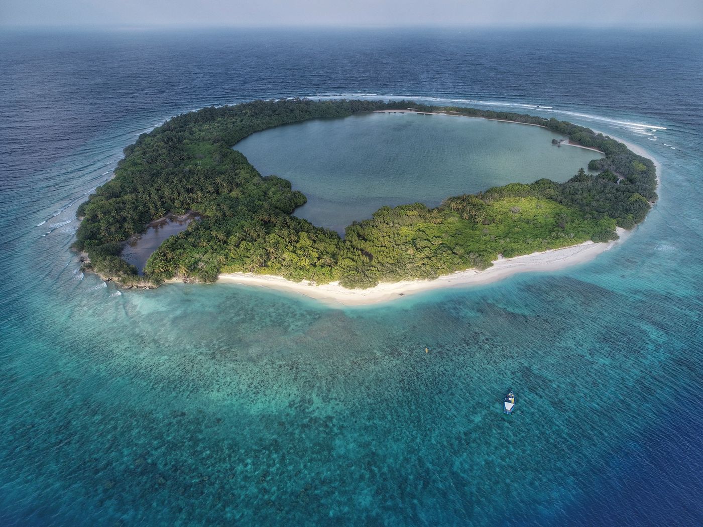 An island in Noonu Atoll, Maldives, seen from the air, surrounded by turquoise water