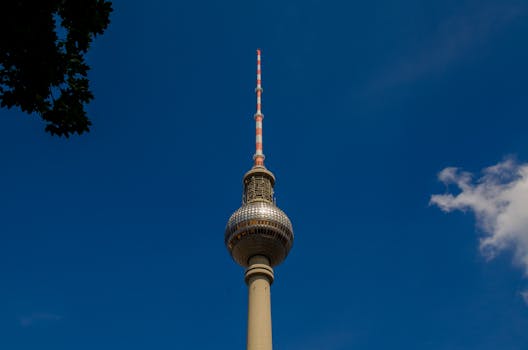 The iconic Berlin TV Tower stands tall under a clear blue sky.