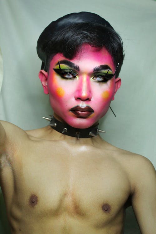 Androgynous man with artistic makeup and collar