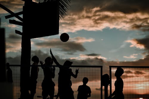 Silhouette of People Playing Basketball During the Dusk