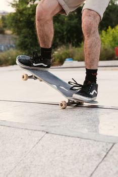 Close-up of a skateboarder performing a trick outdoors in an urban skate park.. close, skateboarder, performing