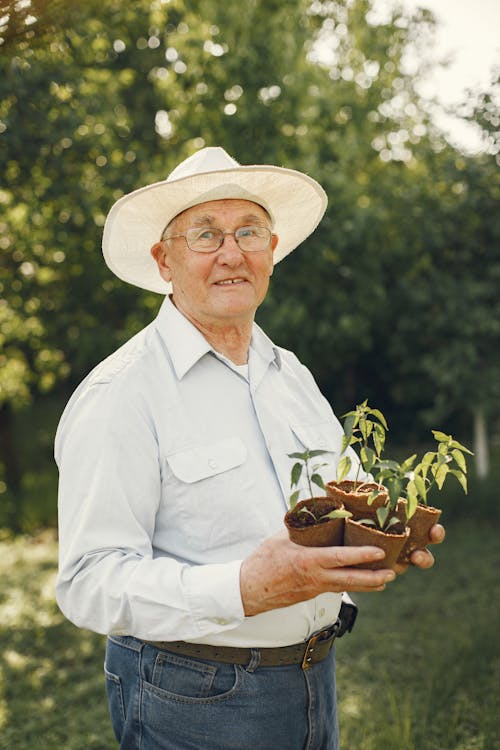 Man Holding Small Pots of Plants
