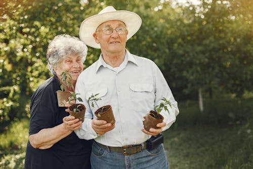  Man and Woman Holding Small Potted Plants
