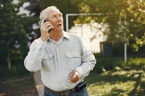 Free Man In Dress Shirt Holding His Phone Stock Photo