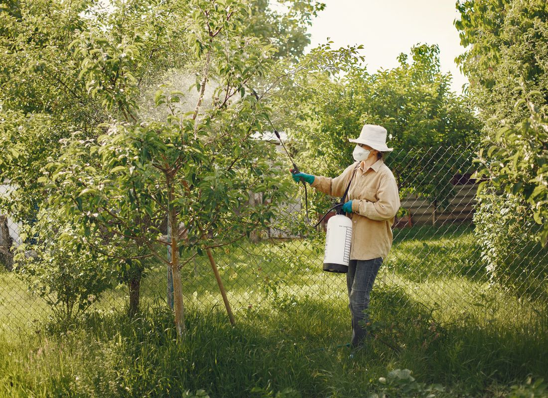 A pest control technician treating the exterior of a coastal Encinitas home