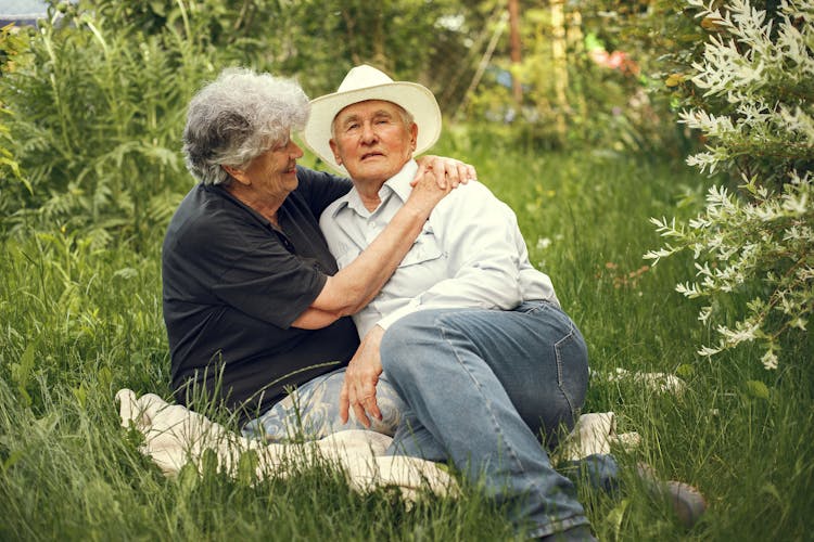 Happy Old Couple Relaxing On Grass