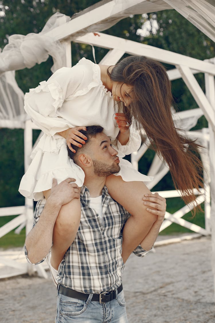 Young Woman Sitting On Man Shoulders