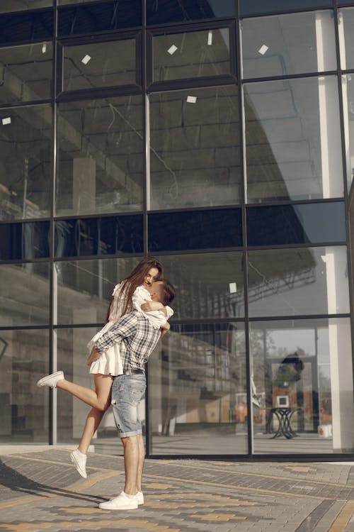 Free Woman in White and Black Plaid Dress Shirt Standing in Front of Glass Building Stock Photo