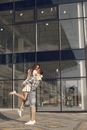 Woman in White and Black Plaid Dress Shirt Standing in Front of Glass Building