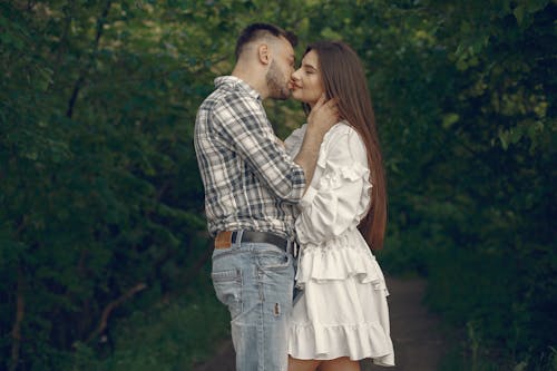 Free Photo of a Man Kissing a Woman in a White Dress Stock Photo