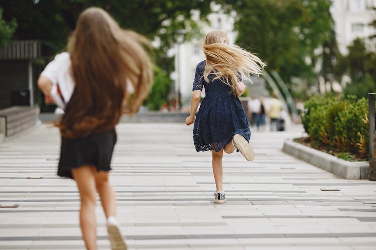 Back View Of A Girl In A Blue Dress Running