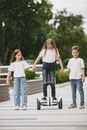 Girl on Balancing Scooter Holding Hands with Friends