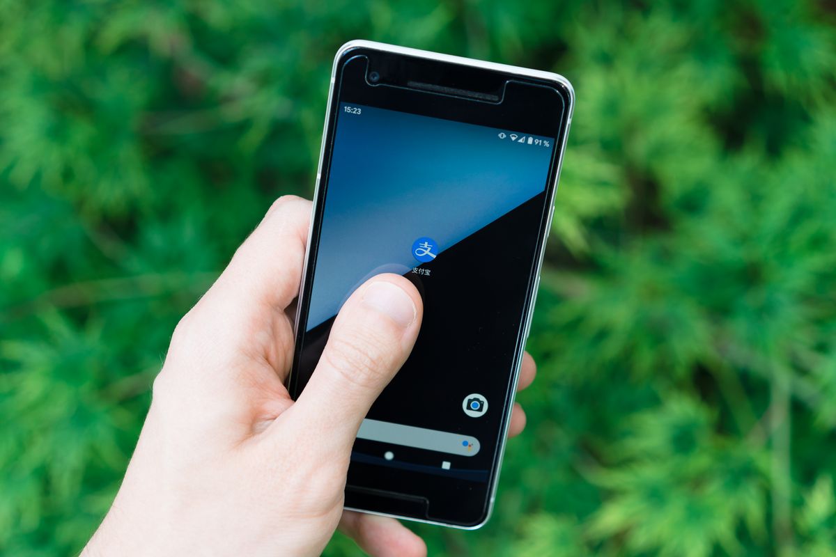 Elde tutulan akıllı telefon ekranı, mobil uygulama simgeleri görünüyor