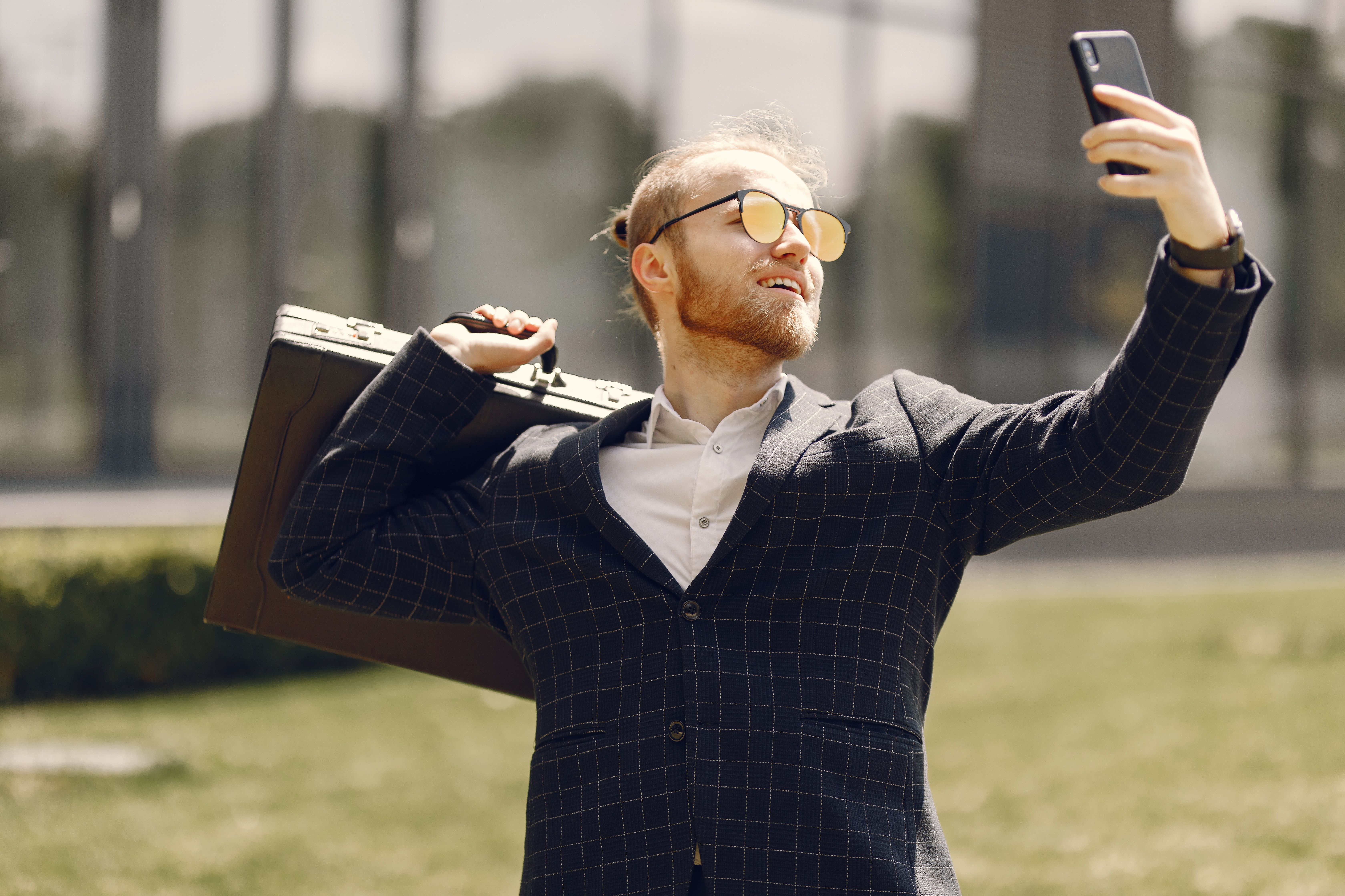 Young person taking a selfie in front of a large LED screen with church branding