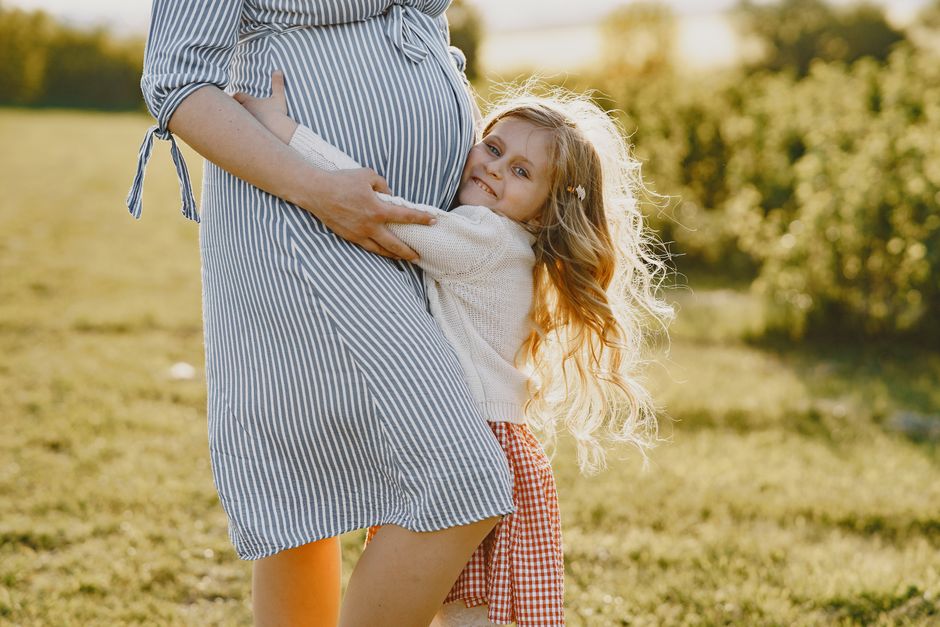 Photo by Gustavo Fring on Pexels A pregnant mother enjoying a tender moment with her daughter in a sunny outdoor setting. - Photo by Gustavo Fring on Pexels