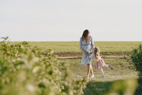 A Pregnant Mother Walking with Her Daughter