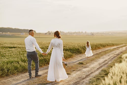 A Couple Walking on Dirt Road Holding Hands