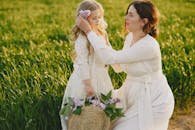 A Woman Putting Flowers on a Girls Head