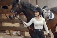 Woman in White Long Sleeve Shirt and Black Cowboy Hat Riding Black Horse