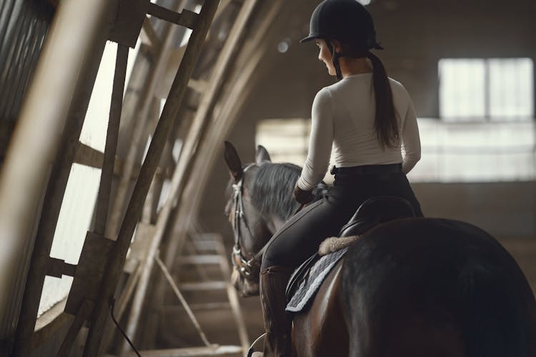 Woman Wearing A Helmet While Riding A Horse