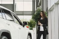 Woman in Black Blazer Standing Beside White Car