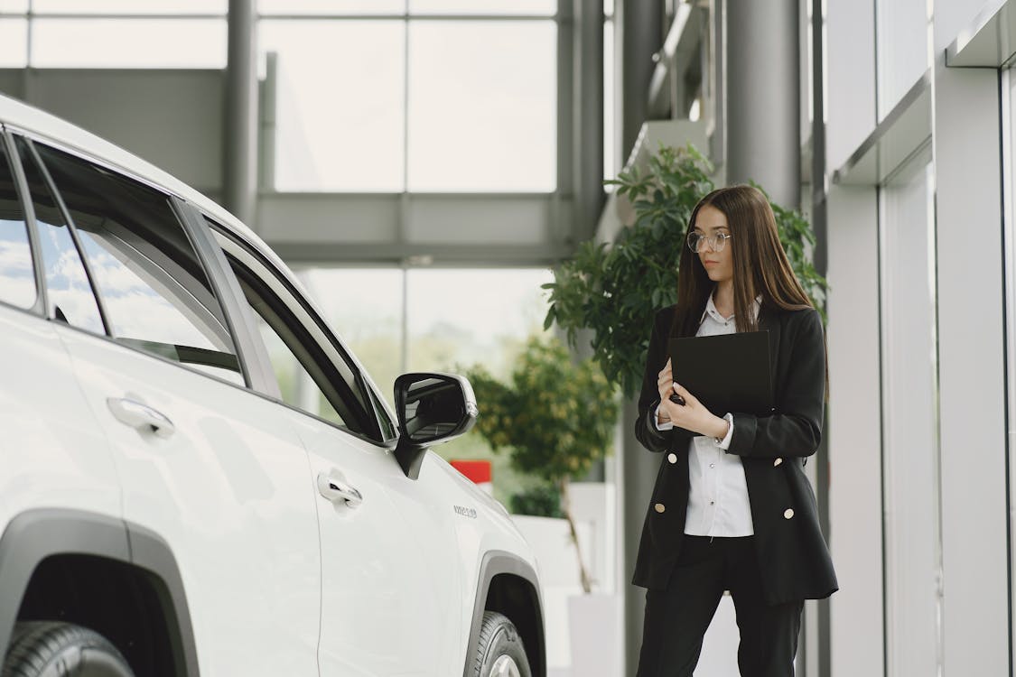 Free Employee of Luxurious Dealership Standing in Front of Car Stock Photo